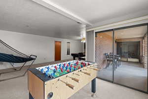 Playroom featuring light colored carpet and brick wall