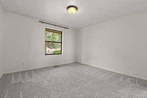 Carpeted empty room featuring baseboards