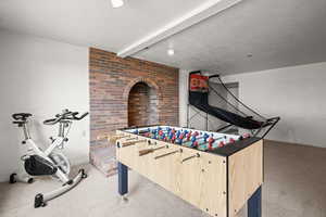 Rec room with light carpet and beamed ceiling