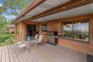 Wooden deck with outdoor dining space and a grill