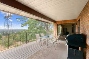 Wooden terrace featuring area for grilling and outdoor dining area