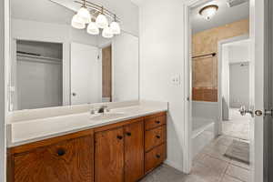 Bathroom with vanity, light tile patterned floors, and light colored carpet