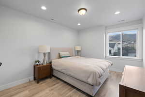 Bedroom with light wood-style floors and recessed lighting