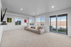 Living room with a wainscoted wall, light colored carpet, a water and mountain view, and recessed lighting