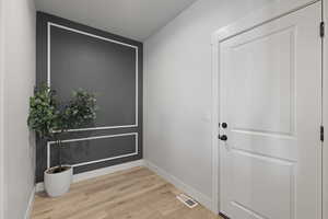 Entryway with wood finished floors and baseboards