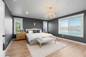 Bedroom featuring light wood-type flooring, a chandelier, recessed lighting, and a water view