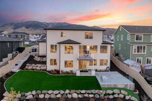 Back of house featuring a fenced backyard, stucco siding, a patio, a mountain view, and a balcony