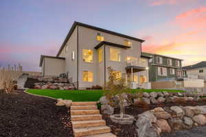 Rear view of house with stairway, a balcony, and stucco siding