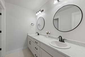Full bathroom featuring double vanity, light marble finish floors, and wooden walls