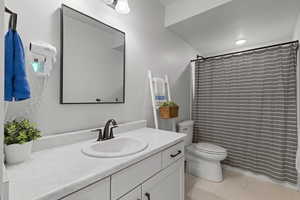 Bathroom featuring vanity, a shower with curtain, and light marble finish floors