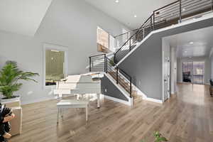 Stairway with a high ceiling and wood finished floors