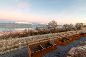 Yard at dusk featuring a garden and a water view