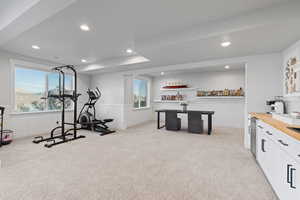 Exercise area with wainscoting, light colored carpet, recessed lighting, bar area, and wine cooler