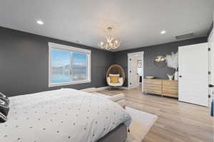 Bedroom featuring a chandelier, light wood-style flooring, and recessed lighting