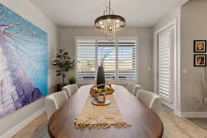 Dining area with light wood-style flooring and a chandelier