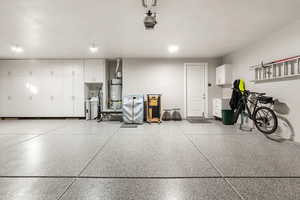 Garage with strapped water heater and a garage door opener