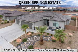View of front facade featuring stucco siding, driveway, a tiled roof, and a mountain view
