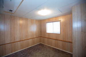 Bedroom 4 with dark colored carpet and paneled walls