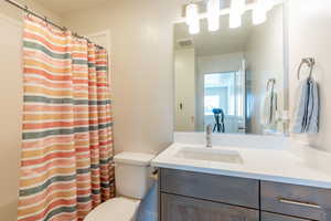 Full bath with a shower with curtain and vanity
