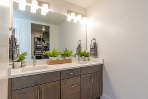 Bathroom with double vanity and a walk in closet