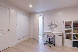 Office space with light wood-style floors and recessed lighting