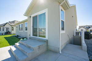 View of side of home with a yard and stucco siding