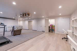 Exercise room featuring recessed lighting and light wood-style flooring