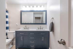 Bathroom with double vanity and a shower with curtain