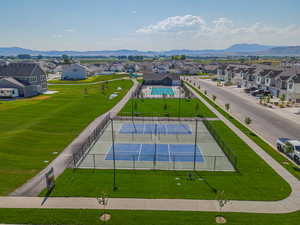 Aerial perspective of suburban area with a mountainous background and a pool