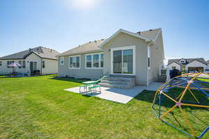 Rear view of house with a patio area, a yard, entry steps, and a shingled roof