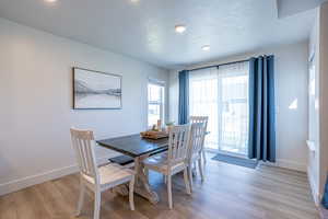 Dining space featuring light wood-style flooring, a textured ceiling, and recessed lighting