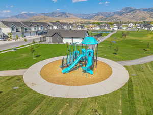 Community play area featuring a mountain view, a lawn, and a residential view