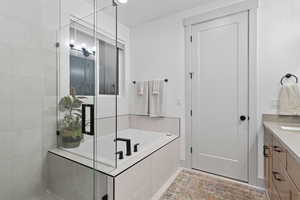 Full bathroom with vanity, a garden tub, and a shower stall