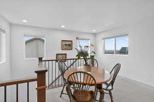 Carpeted dining area featuring recessed lighting