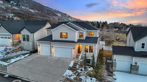 View of front of property featuring board and batten siding, driveway, and an attached garage