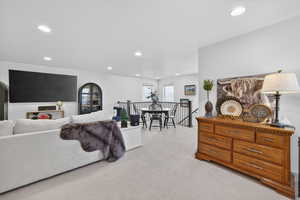 Living area featuring light colored carpet and recessed lighting