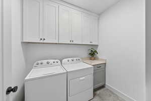 Laundry area with washing machine and clothes dryer and cabinet space