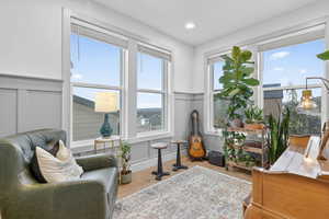 Living area featuring a decorative wall, a wainscoted wall, wood finished floors, and recessed lighting
