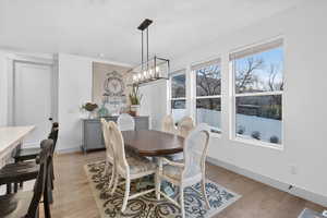 Dining room with light wood-style floors and a chandelier