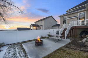 Patio terrace at dusk featuring a patio, a fire pit, a fenced backyard, and area for grilling