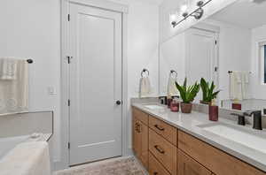 Full bathroom featuring double vanity and a tub