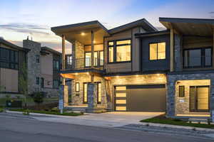 Contemporary home with a balcony and stone siding