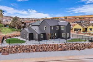 Back of property featuring a residential view, a metal roof, a fenced backyard, and stucco siding