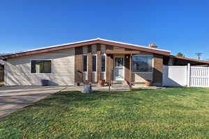 View of front of home featuring brick siding, a patio, and a chimney