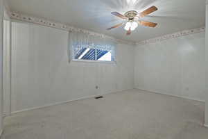 Spare room featuring speckled floor and a ceiling fan