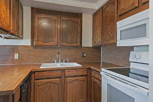 Kitchen with white appliances, wood finish cabinetry, and decorative backsplash