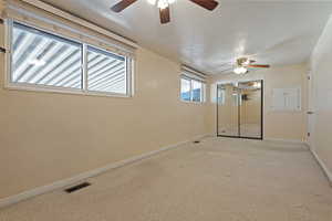Empty room with a textured ceiling and a ceiling fan