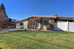 View of front of property with brick siding, a patio, and a chimney