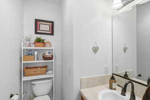 Half bathroom featuring vanity and toilet