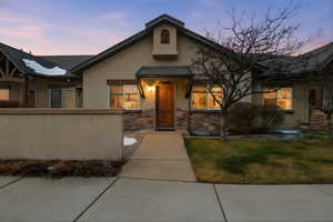 View of front of property with stucco siding, stone siding, and a front yard